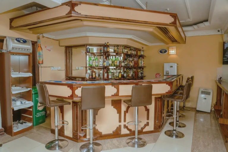 Timber bar with high stools and shelves of spirits