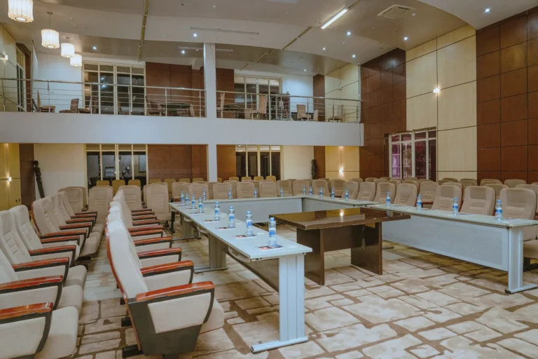 Conference hall set up with U-shaped tables and a mezzanine gallery