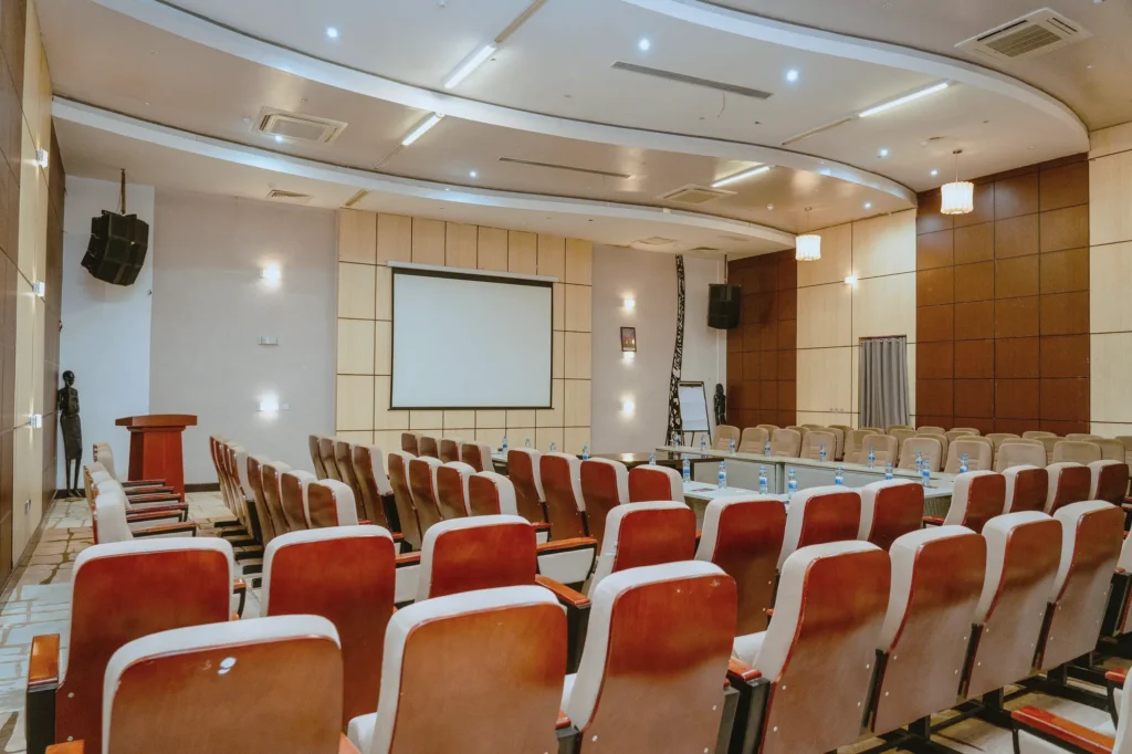 Conference hall with a lectern, speakers and tiered seating