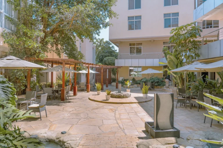 Garden courtyard with umbrellas, tables and a water feature