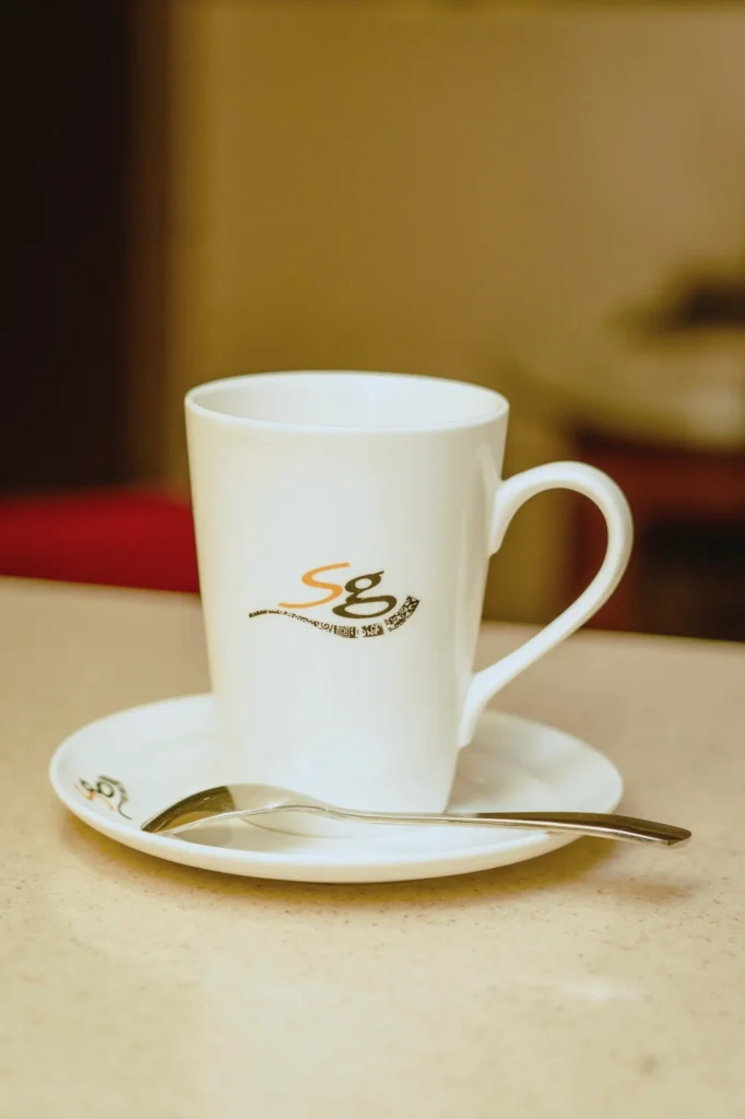 White cup and saucer printed with the SG logo
