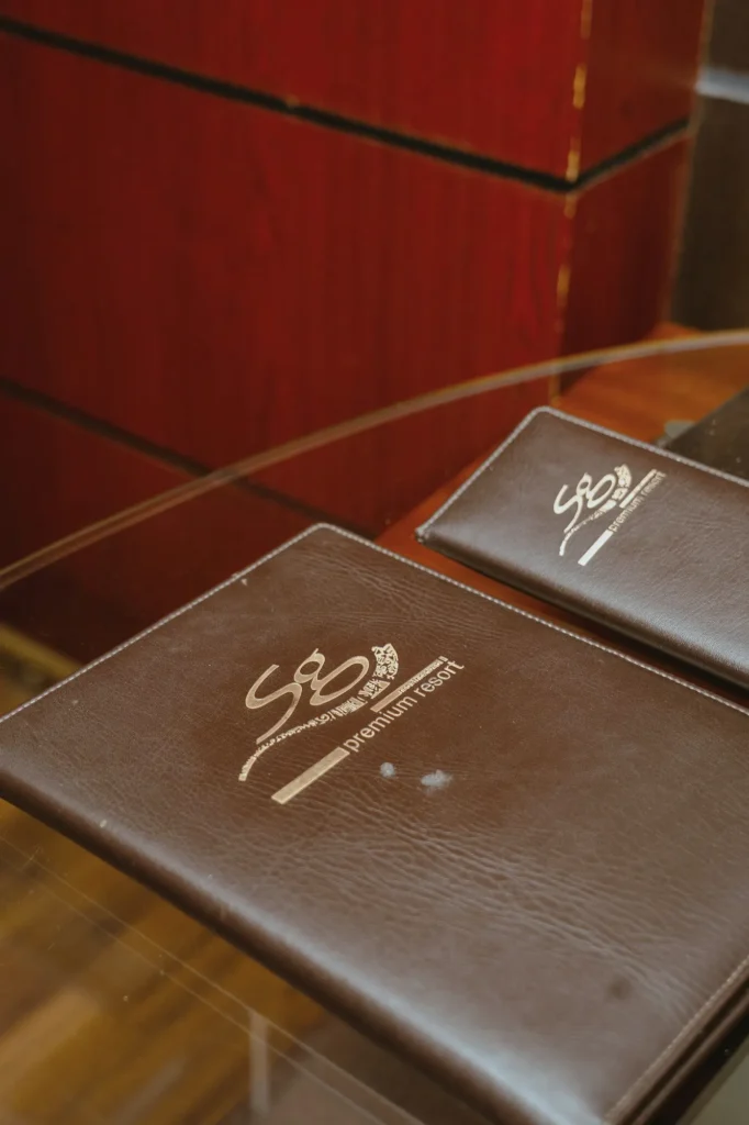 Leather guest folders embossed with the SG logo on a glass desk