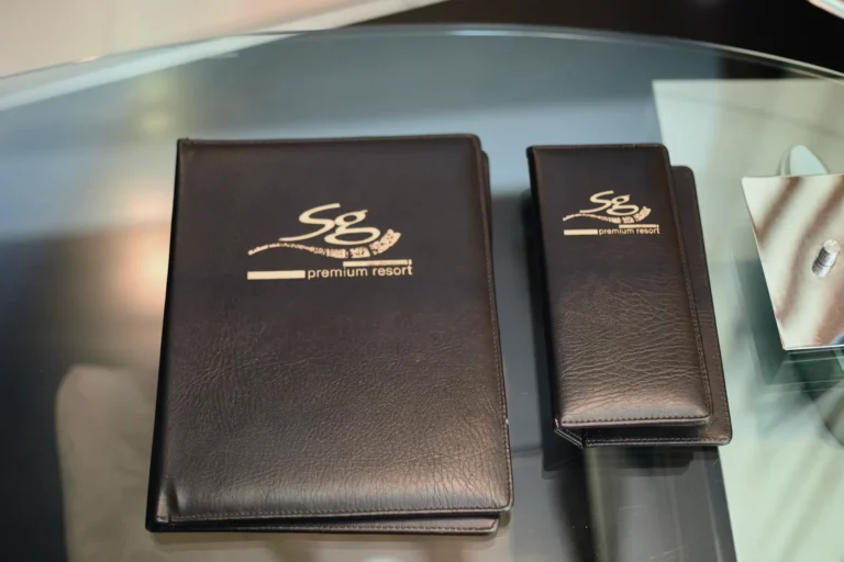 Two brown leather folders with the gold SG Premium Resort logo