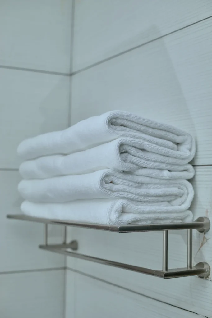 Folded white towels on a chrome rail