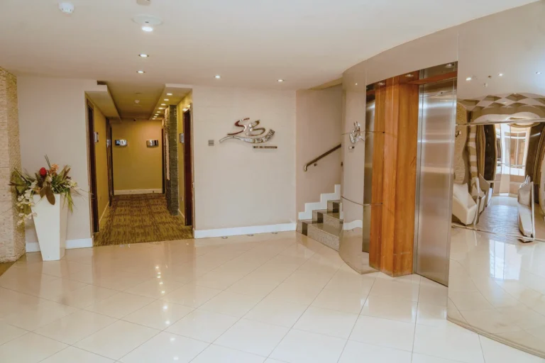 Corridor entrance beside the brushed-metal SG logo on the wall