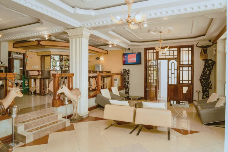Lobby lounge with white columns, a chandelier, antelope sculptures and carved wooden figures