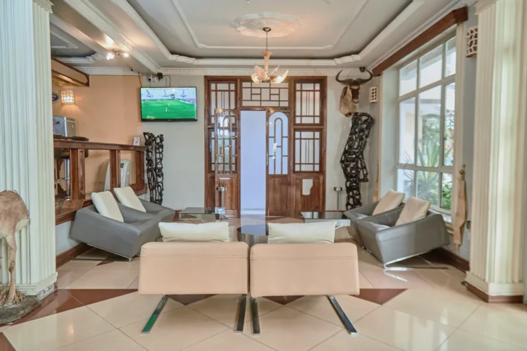 Lounge with cream armchairs, a chandelier and carved timber doors