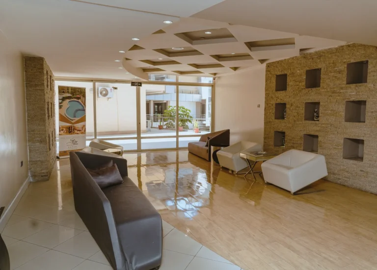 Lounge with a stone niche wall, dark sofas and glass doors