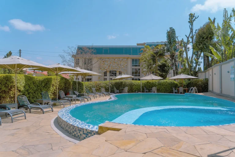 Pool with stone paving and garden hedges under a blue sky