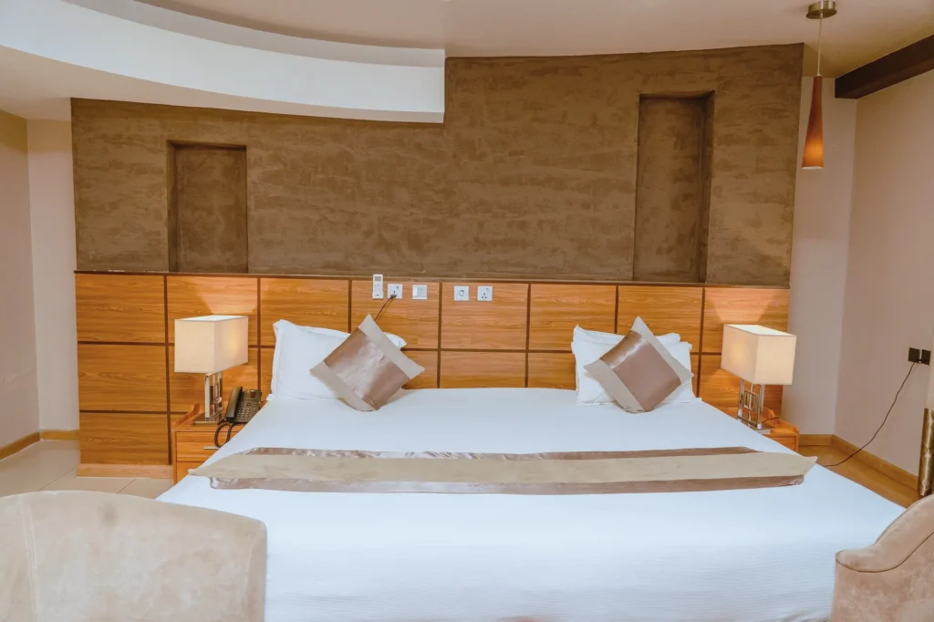 Suite with a honey-toned timber headboard and bedside lamps